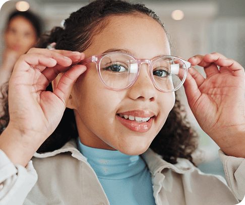 Young patient trying on glasses at optometry appointment